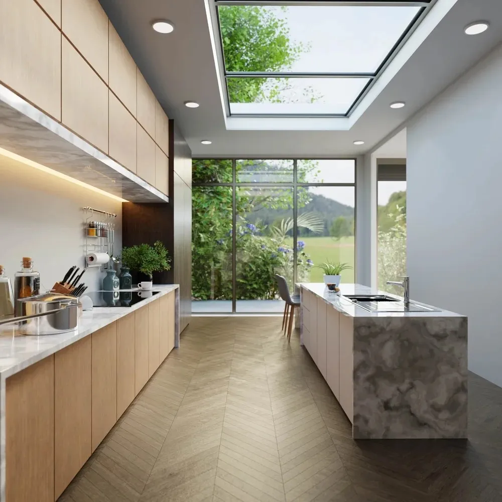 Modern kitchen with wooden cabinets, marble counters, a skylight, and large windows overlooking green outdoor scenery.